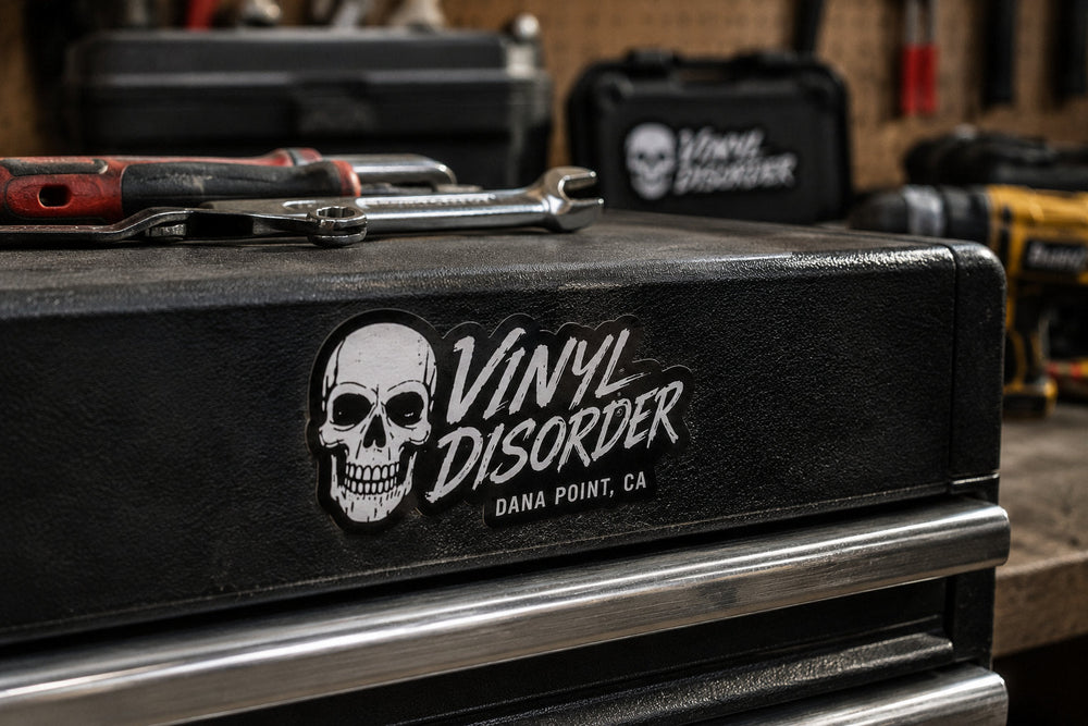 Vinyl Disorder sticker applied to a textured black contractor toolbox in a workshop