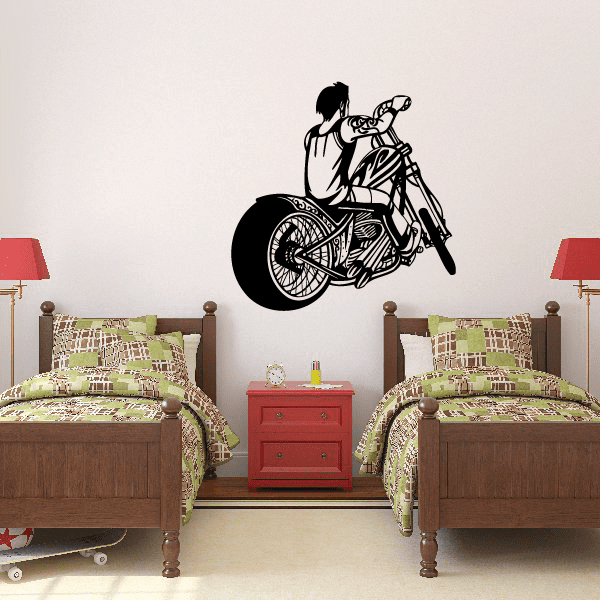 Black vinyl wall decal of a boy riding a motorcycle with helmet and hands on handlebars.