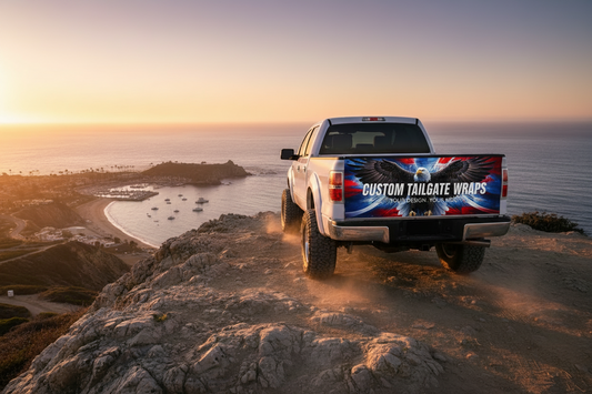 A custom tailgate skin with a fiery orange and black design, applied on the rear window of a white pickup truck.