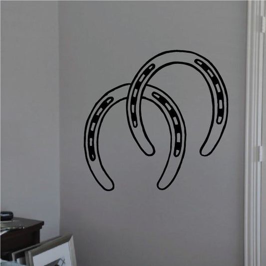 Double horseshoe decal, black outlined horseshoe shapes on a light surface
