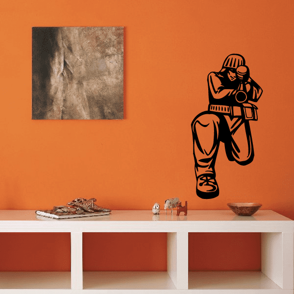 Front view paintball player decal with black and orange outline on wall