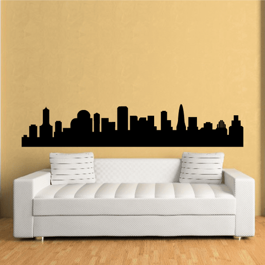 Black city skyline wall decal silhouette above white sofa