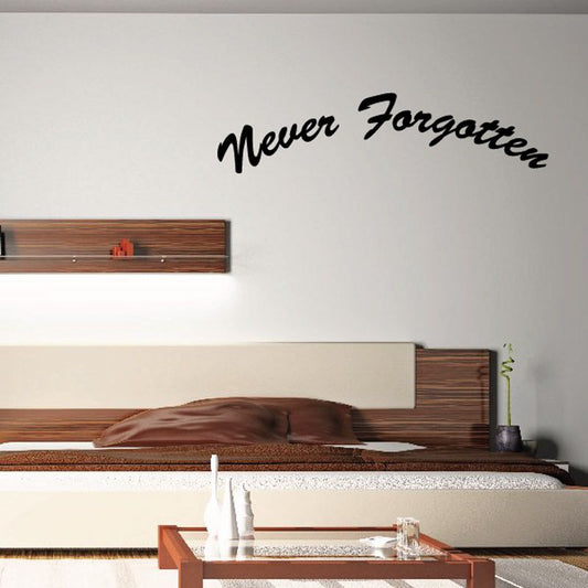 Wall decal with black cursive “Never Forgotten” text on a light wall.
