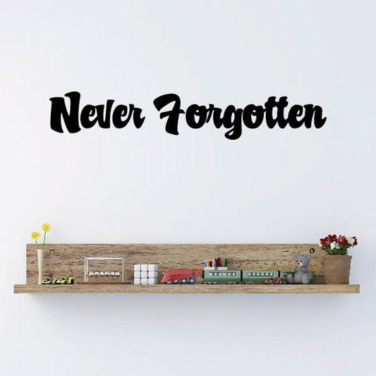 Wall decal with 'Never Forgotten' black script and small shelf scene, vinyl lettering