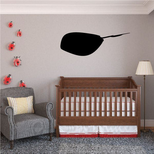 Black stingray wall decal with round body and tail silhouette