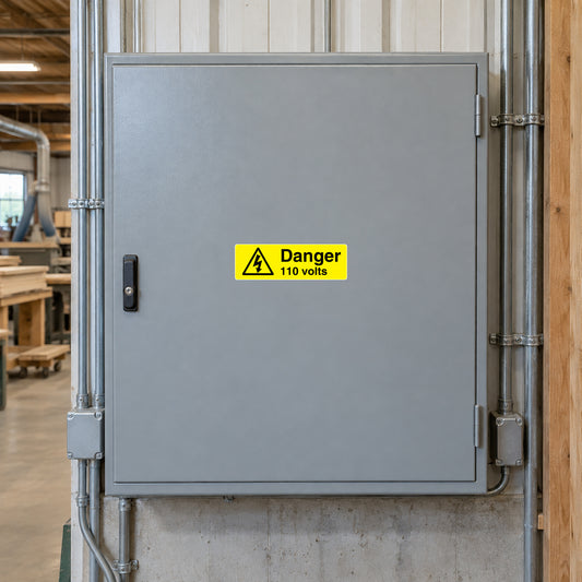 Rectangular warning sticker: 'Danger 110 volts' with hazard triangle