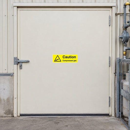 Compressed gas caution sticker: yellow triangle with 'Caution Compressed gas' text