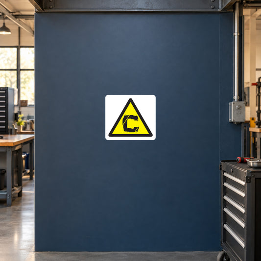 Yellow triangular caution symbol sticker on a workshop service panel
