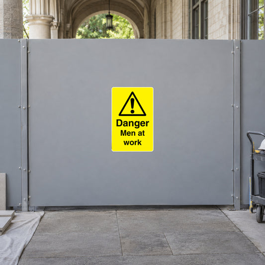 Danger warning sticker on gray metal safety panel, yellow with black exclamation