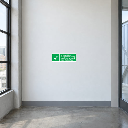 Fire safety escape sticker with green check icon and text, mounted on white wall