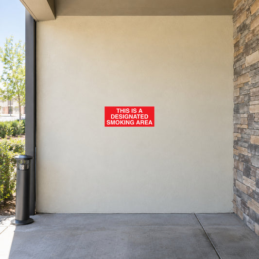 NO Smoking Sign Sticker applied in solid cream sheltered OUTDOOR smoking area side wall, open air and unoccupied metal ash receptacle at extreme edge, no enclosed indoor space