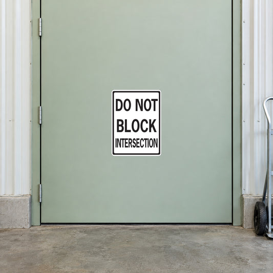 Road Sign Sticker applied in A pale sage warehouse traffic control equipment door with dolly extreme right and concrete floor below, smooth blank central panel
