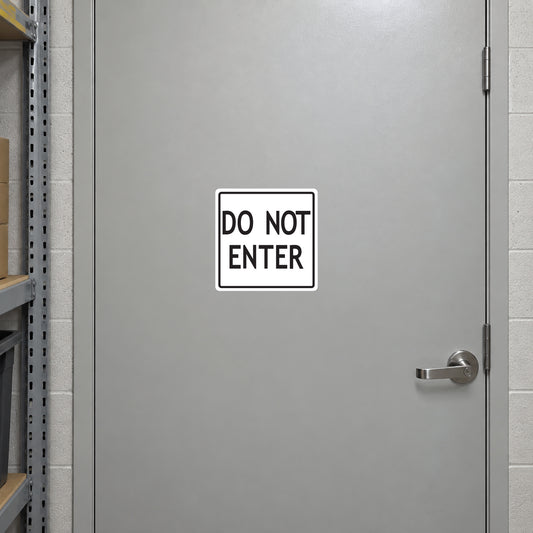 Road Sign Sticker applied in A light grey stockroom restricted access steel door with lever at extreme right and shelf edge far left, broad smooth blank center