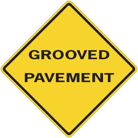 Road sign sticker with yellow diamond and text “GROOVED PAVEMENT”