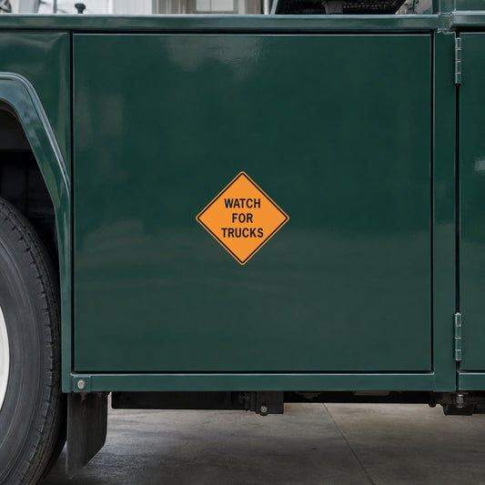 Yellow diamond warning sticker reading "WATCH FOR TRUCKS"