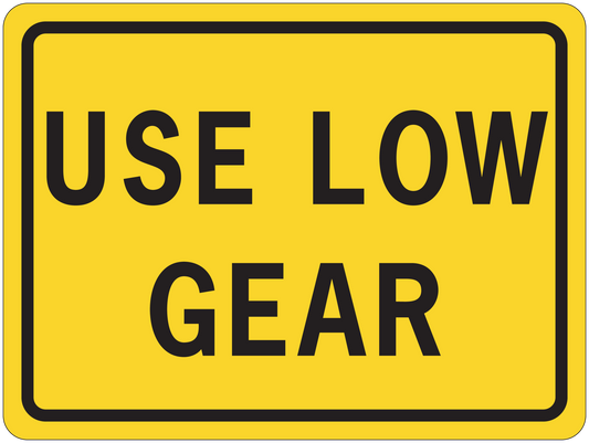 Road sign sticker, yellow with black border and text “USE LOW GEAR”