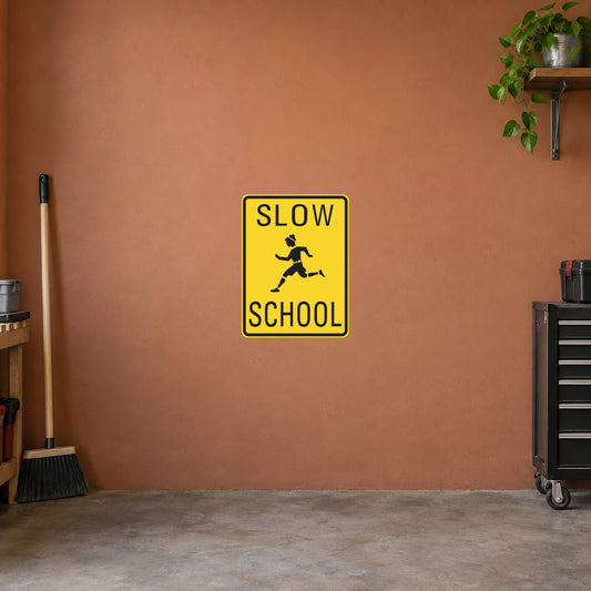 Yellow road sign sticker with black “SLOW” and “SCHOOL” text and a walking child icon