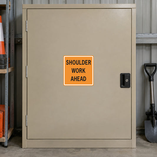 Road sign sticker with orange outline text: 'SHOULDER WORK AHEAD'