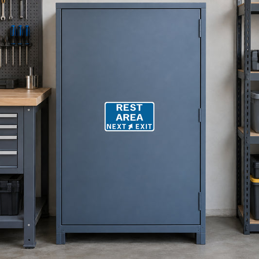 Road sign sticker with blue background and white “REST AREA NEXT EXIT” text