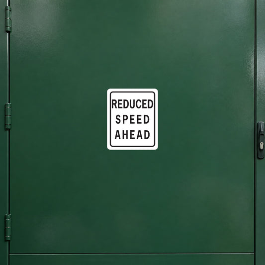 Road sign warning sticker: white square with “REDUCED SPEED AHEAD” text