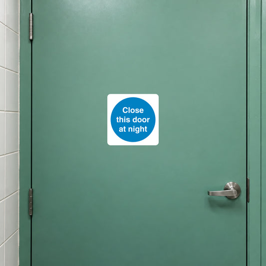 Safety sign sticker with blue circle text: “Close this door at night”