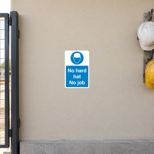 Safety Sign Sticker applied in a smooth light sand wall at a construction workforce entrance, hard hat hooks extreme right and gate frame far left, centre clear