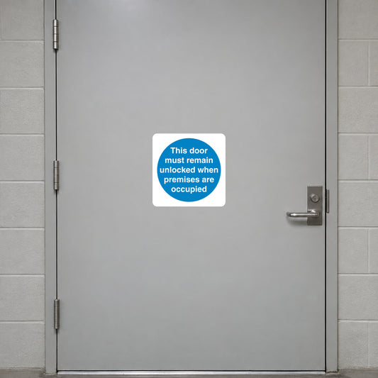 Safety Sign Sticker applied in a smooth pale grey closed emergency exit door at a community centre, latch extreme right and hinges far left, central unbroken face