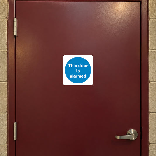 Safety Sign Sticker applied in Blank flat burgundy steel security door, lever at extreme lower right below y80%, slim door frame on edges, warm warehouse corridor light