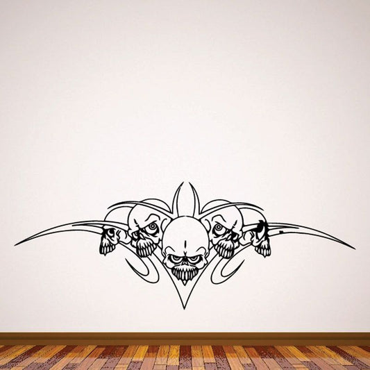 Black skull wall decal with central skull, flanking skulls and winged tribal outline