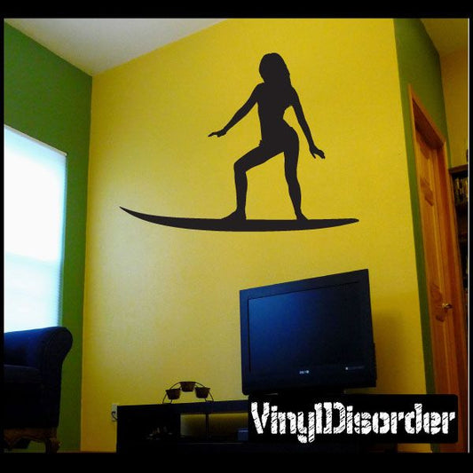 Surfing wall decal with black surfer silhouette standing on a surfboard