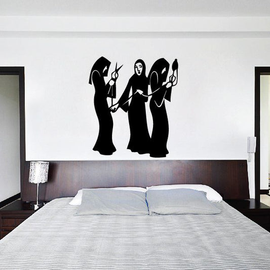 Black silhouette wall decal of three women in a trio, one central figure flanked by two