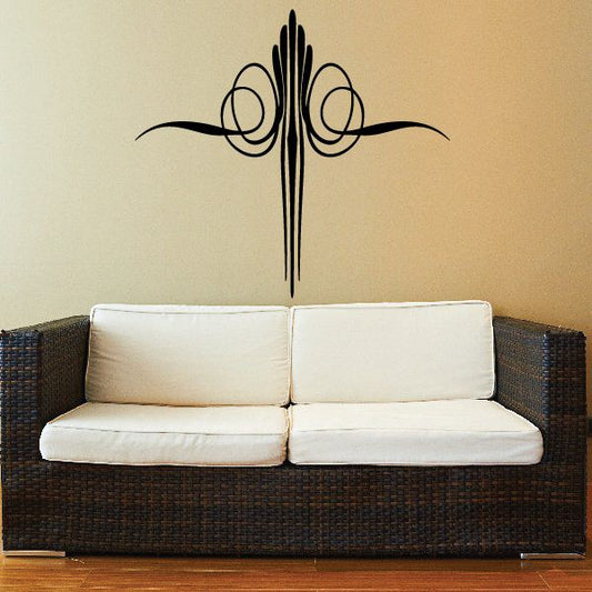 Pinstripe vinyl car decal cross with swirling flourishes, black on light wall