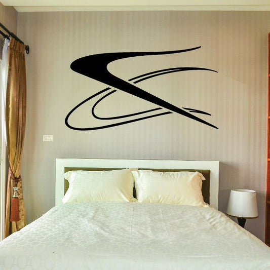 Vehicle pinstripe vinyl decal with sweeping black stripe design on a wall