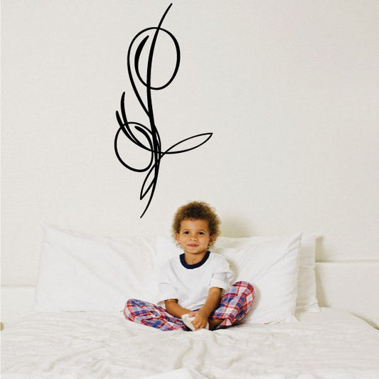 Black vinyl pinstripe decal with looping swirl and leaf accents on a wall