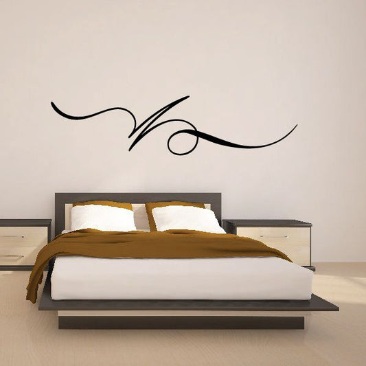 Black pinstripe vinyl decal swirl with small circular accent on wall