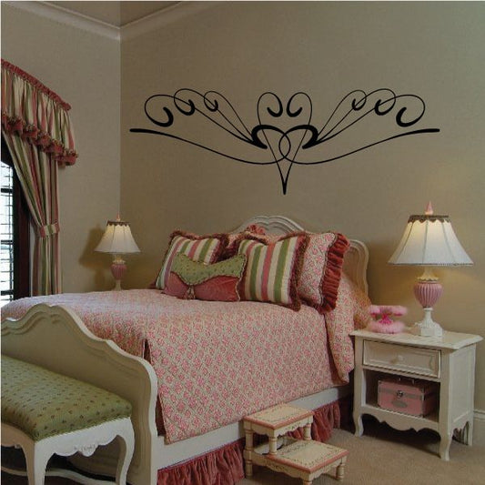 Ornamental black pinstripe vinyl decal with central heart and scrolling wings