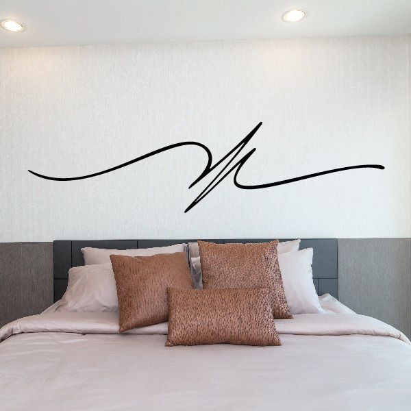 Black pinstripe script vinyl decal on the wall above a bed