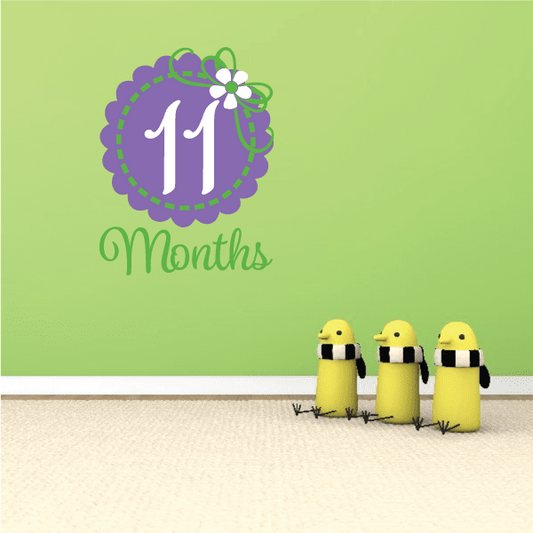 11 months wall decal with purple circle "11", white number, green dashed border and flower