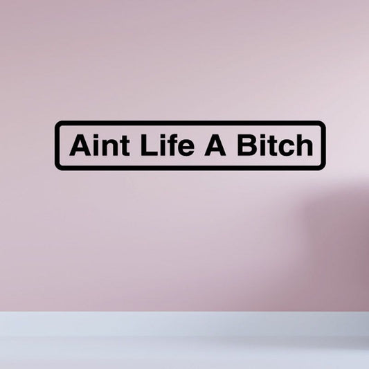 Vinyl wall decal with black border text "Aint Life A Bitch"