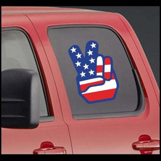 America flag peace sticker with blue hand holding red-white ribbon, on car window