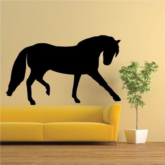 Black trotting horse wall decal with legs stretched and tail raised