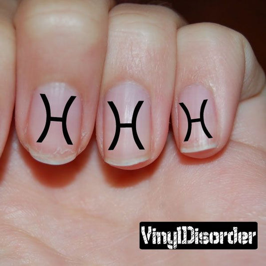 Astrology nail art stickers with black Pisces symbols on nude nails
