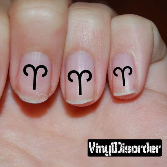 Fingernail art sticker with black Aries symbol on nude nails