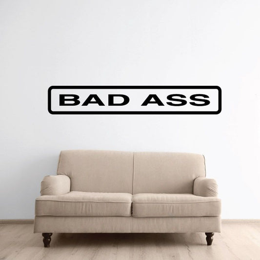Wall decal with bold 'BAD ASS' text, black letters in a white bordered rectangle