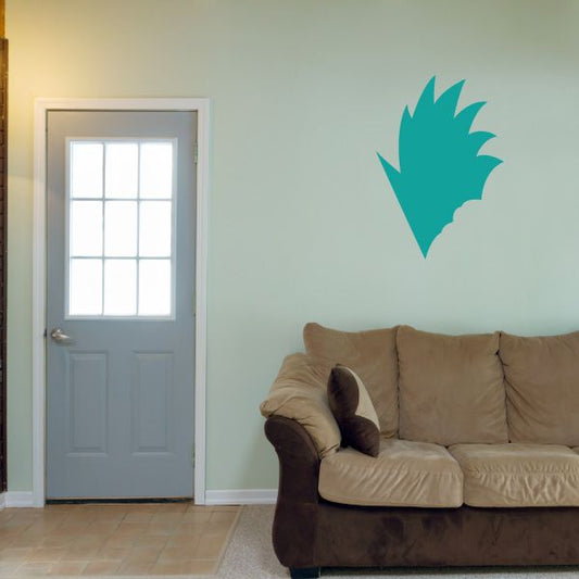 Vinyl wall decal of teal character face silhouette above sofa