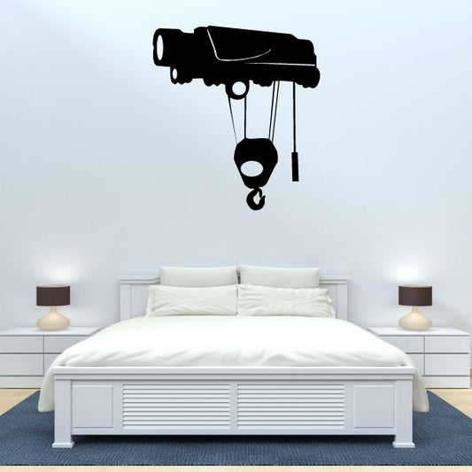 Crane pulley wall decal with black hoist, ropes, and hook above bed