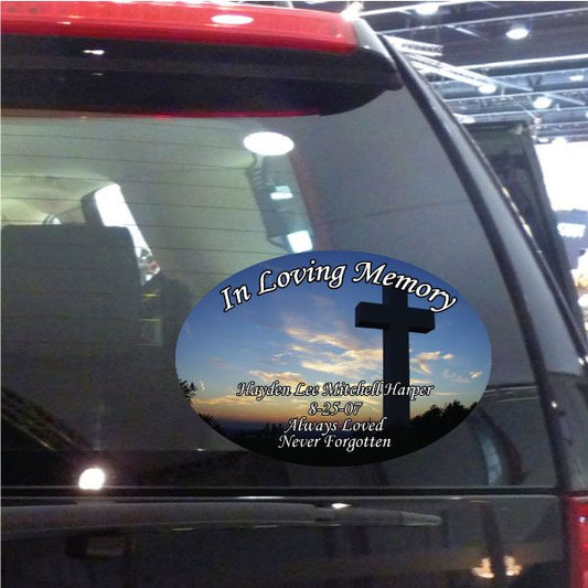 Oval memorial sticker with black cross and 'In Loving Memory' text