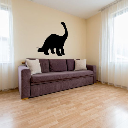 Black brontosaurus dinosaur vinyl wall decal silhouette above sofa