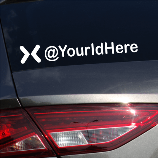 Die-cut decal with white ><@YourIdHere text on dark surface