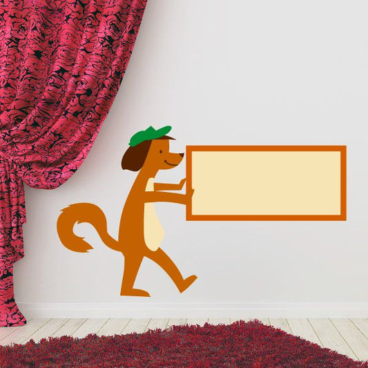 Dog holding sign sticker: orange-brown dog with green hat, holding blank orange-framed rectangle